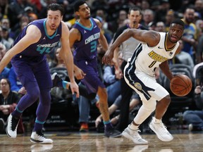 Denver Nuggets guard Emmanuel Mudiay, right, picks up a loose ball from Charlotte Hornets forward Frank Kaminsky in the second half of an NBA basketball game Monday, Feb. 5, 2018, in Denver. The Nuggets won 121-104.