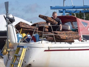 A Canada Border Services Agency officer inspects the sailboat Quesera at East River Marine in Hubbards, N.S., on Friday, Sept. 8, 2017. A Nova Scotia sailboat captain is due in court today for a sentencing hearing after being convicted of having 250 kilograms of cocaine on his vessel.