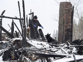 An RCMP dog handler and a human remains detection dog search the scene of a house destroyed in a weekend fire in Pubnico Head, N.S. on Monday, Jan. 8, 2018. Nova Scotia's fire marshal says heat from a wood stove caused a fire last month that claimed the lives of four children in rural Pubnico Head.