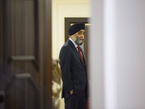 Minister of National Defence Minister Harjit Singh Sajjan waits for the start of a news conference in New Delhi, India on Friday, Feb. 23, 2018. Sajjan says the military is looking to settle several class-action lawsuits filed by members of the Canadian Armed Forces.