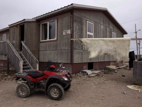 A polar bear hide hangs drying outside of a house in the town of Gjoa Haven, Nunavut on Saturday September 2, 2017. The federal government will make a long-term funding commitment to Indigenous housing in next week's budget worth hundreds of millions of dollars,