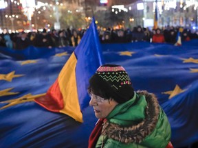People hold a large European Union flag during protest joined by hundreds in Bucharest, Romania, Sunday, Dec. 3, 2017. Asylum claims from Romanians have risen substantially since the Liberal government lifted the requirement that Romanians get a visa to enter Canada.