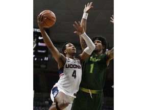 Connecticut's Jalen Adams, left, goes up for a basket as South Florida's Isaiah Manderson, right, defends during the first half an NCAA college basketball game, Wednesday, Feb. 7, 2018, in Storrs, Conn.