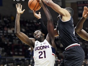 Connecticut's Mamadou Diarra (21) battles Cincinnati's Kyle Washington (24) for a rebound in the first half of an NCAA college basketball game Saturday, Feb. 3, 2018, in Storrs, Conn.