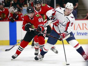 Chicago Blackhawks right wing Patrick Kane (88) battles Washington Capitals defenseman Dmitry Orlov (9) for the puck during the first period of an NHL hockey game Saturday, Feb. 17, 2018, in Chicago.