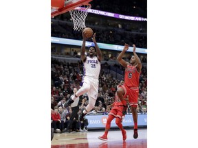 Philadelphia 76ers' Joel Embiid (21) scores past Chicago Bulls' Cristiano Felicio (6) during the first half of an NBA basketball game Thursday, Feb. 22, 2018, in Chicago.