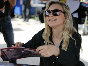 Natalie Decker, pole sitter for the ARCA auto race at Daytona International Speedway, signs autographs, Saturday, Feb. 10, 2018, in Daytona Beach, Fla.