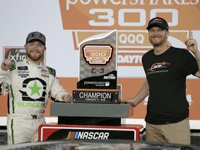 Tyler Reddick, left, and team owner Dale Earnhardt Jr., right, pose with the trophy in Victory Lane after winning the NASCAR Xfinity series auto race at Daytona International Speedway in Daytona Beach, Fla., Saturday, Feb. 17, 2018.