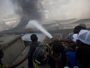 Firefighters work to extinguish a massive fire at the biggest clothing market in Port-au-Prince, Haiti, Sunday, Feb. 18, 2018. The entire market, which was closed, was affected where at least 1,000 vendors work.