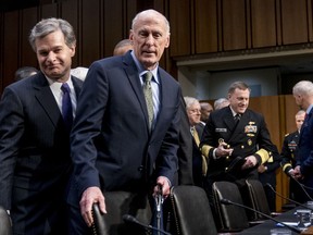 FBI Director Christopher Wray, left, and Director of National Intelligence Dan Coats, second from left, arrive for a Senate Select Committee on Intelligence hearing on worldwide threats, Tuesday, Feb. 13, 2018, in Washington.