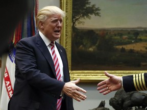 President Donald Trump shakes hands with Immediate Past President of the National Sheriffs' Association, St. Charles Parish, La., Sheriff Greg Champagne, as he arrives for a roundtable discussion with members the National Sheriffs' Association and others in the Roosevelt Room of the White House in Washington, Tuesday, Feb. 13, 2018.