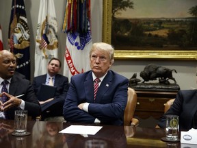 Florida Attorney General Pam Bondi, right, and President Donald Trump listen as Indiana Attorney General Curtis Hill speaks during a meeting with state and local officials to discuss school safety, in the Roosevelt Room of the White House, Thursday, Feb. 22, 2018, in Washington.