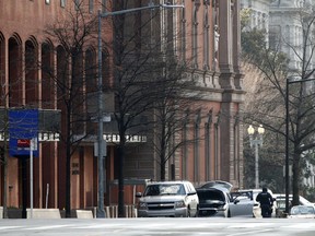 Police are seen searching a suspicious vehicle near the White House, Wednesday, Feb. 21, 2018 in Washington.  The Secret Service said the New Executive Office Building, left, was evacuated and a portion of 17th Street had been closed to vehicle traffic.
