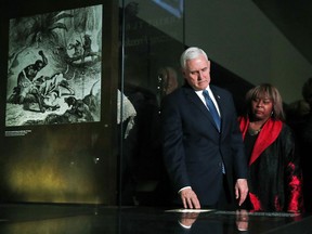 Vice President Mike Pence, left, looks at exhibits during a tour of the Smithsonian's National Museum of African American History and Culture, Tuesday, Feb. 13, 2018, in Washington, with Renee Amoore, Chairman of the Pennsylvania New Majority Council, right.