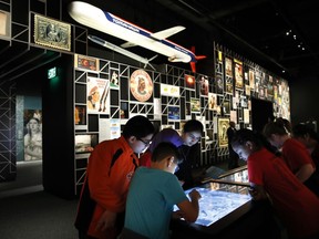 A school groups explores an interactive touch table to learn about the objects and images on display at the "Americans" exhibit at the Smithsonian's National Museum of the American Indian, Friday, Feb. 9, 2018, in Washington. The exhibit uses Native imagery to show how it permeates American culture.