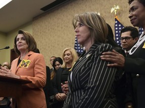 House Minority Leader Nancy Pelosi of Calif., left, speaks during a news conference on Capitol Hill in Washington, Tuesday, Jan. 30, 2018, about legislation to protect Deferred Action for Childhood Arrivals program recipients. Rep. Michelle Lujan Grisham, D-N.M., center, chairwoman of the Congressional Hispanic Caucus, listens