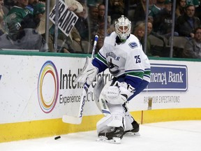 Vancouver Canucks goaltender Jacob Markstrom (25) protects the puck against the Dallas Stars during the first period of an NHL hockey game in Dallas, Sunday, Feb. 11, 2018.