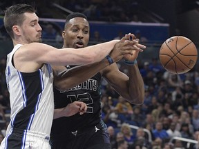 Orlando Magic guard Mario Hezonja, left, strips the ball away from Charlotte Hornets center Dwight Howard (12) during the first half of an NBA basketball game Wednesday, Feb. 14, 2018, in Orlando, Fla.