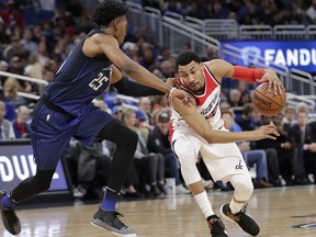 Washington Wizards' Otto Porter Jr., right, drives past Orlando Magic's Wesley Iwundu (25) during the first half of an NBA basketball game Saturday, Feb. 3, 2018, in Orlando, Fla.