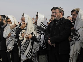 FILE - In this  Jan. 10, 2018 file photo, Israelis pray during the funeral of Raziel Shevah in Havat Gilad, an unauthorized Israeli settlement outpost near the Palestinian city of Nablus.