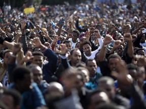 FILE - In this Jan. 5, 2014 file photo, African migrants chant slogans during a protest in Rabin Square in Tel Aviv, Israel. On Sunday, Feb. 4, 2018, Israeli authorities began distributing deportation notices to thousands of African migrants saying the migrants have 60 days to accept the offer to leave the country for an unnamed African destination in exchange for $3,500 and a plane ticket. Those who don't by Apr. 1 will be incarcerated indefinitely.