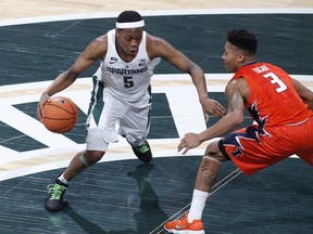 Michigan State's Cassius Winston, left, drives against Illinois' Te'Jon Lucas (3) during the first half of an NCAA college basketball game Tuesday, Feb. 20, 2018, in East Lansing, Mich.