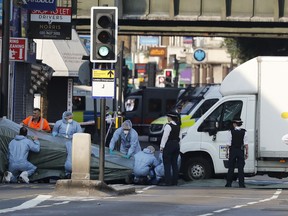 FILE - In this file photo dated Monday, June 19, 2017, forensic officers move the van which struck pedestrians near a Mosque at Finsbury Park in north London.  A Crown Court on Thursday Feb. 1, 2018, found Darren Osborne guilty of murder and attempted murder in the June 2017 attack in the city's Finsbury Park neighborhood.