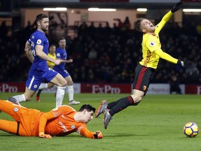 Chelsea's goalkeeper Thibaut Courtois, left, fouls Watford's Gerard Deulofeu, right, during the English Premier League soccer match between Watford and Chelsea at Vicarage Road stadium in London, Monday, Feb. 5, 2018.