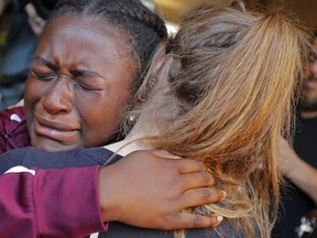 Marla Eveillard, 14, cries as she hugs friends before the start of a vigil at the Parkland Baptist Church, for the victims of Wednesday's shooting at the Marjory Stoneman Douglas High School in Parkland, Fla., Thursday, Feb. 15, 2018. Nikolas Cruz, a former student, was charged with 17 counts of premeditated murder Thursday morning.