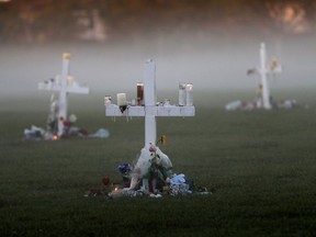 An early morning fog rises where 17 memorial crosses were placed, for the 17 deceased students and faculty from the Wednesday shooting at Marjory Stoneman Douglas High School, in Parkland, Fla., Saturday, Feb. 17, 2018.  As families began burying their dead, authorities questioned whether they could have prevented the attack at the high school where a gunman, Nikolas Cruz, took several lives.