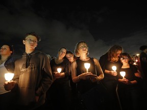 People participate in a candlelight vigil in memory of the 17 students and faculty who were killed in the Wednesday mass shooting at Marjory Stoneman Douglas High School in Parkland, Fla., Monday, Feb. 19, 2018. Nikolas Cruz, a former student, was charged with 17 counts of premeditated murder.