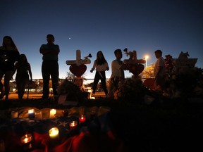 People visit a makeshift memorial outside Marjory Stoneman Douglas High School, where 17 students and faculty were killed in Wednesday's mass shooting in Parkland, Fla., Sunday, Feb. 18, 2018. Nikolas Cruz, a former student, was charged with 17 counts of premeditated murder on Thursday.