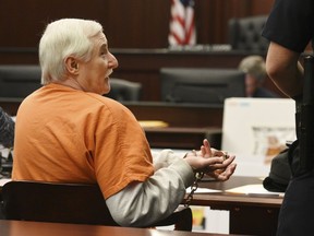 Donald Smith presents his handcuffs to be unlocked by a bailiff so he can sign paperwork early in Tuesday's court proceedings Tuesday, Feb. 20, 2018, in the courtroom of Judge Mallory Cooper in Jacksonville, Fla. After being found guilty in the kidnapping, rape and murder of 8-year-old Cherish Perrywinkle, the trial of Smith  continued into the death penalty phase Tuesday. (Bob Self/The Florida Times-Union via AP