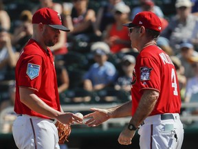 Minnesota Twins manager Paul Molitor, right, takes the ball from relief pitcher Ryan Pressly, left, as he is relieved in the fourth inning of a spring training baseball game, Sunday, Feb. 25, 2018, in Fort Myers, Fla.