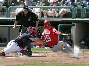 Atlanta Braves catcher Tyler Flowers, left, tags out Washington Nationals' Matt Reynolds as he tagged up on fly ball in the second inning of an exhibition spring baseball game, Monday, Feb. 26, 2018, in Kissimmee, Fla.