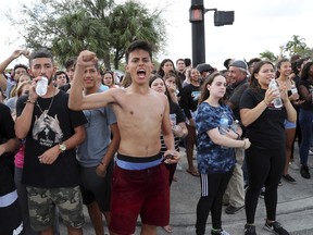 West Boca Raton Community High School students cheer after reaching Marjory Stoneman Douglas High School in Parkland, Fla., Tuesday, Feb. 20, 2018. Hundreds of students from the high school walked out Tuesday and made their way to the site of a school shooting about 10 miles (16 kilometers) away in a show of solidarity for bringing an end to gun violence.