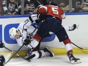 Los Angeles Kings' Dustin Brown, left, and Florida Panthers' Aaron Ekblad (5) go for the puck during the first period of an NHL hockey game Friday, Feb. 9, 2018, in Sunrise, Fla.