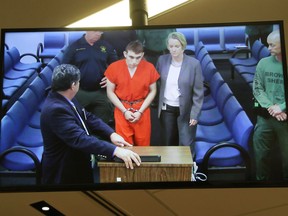 Assistant public defender Hector Romero and public defender Melisa McNeill are seen on screen at the first appearance in court for high school shooting suspect Nikolas Cruz (C) on February 15, 2018 at Broward County Court House in Fort Lauderdale, Florida.