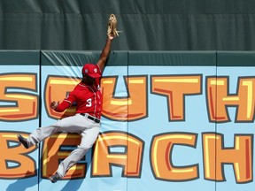 Washington Nationals center fielder Michael A. Taylor leaps at the wall to catch a fly ball by Miami Marlins' Derek Dietrich to end the third inning of an exhibition spring training baseball game, Wednesday, Feb. 28, 2018, in Jupiter, Fla.