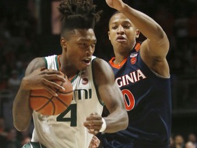 Miami guard Lonnie Walker IV (4) drives to the basket against Virginia guard Devon Hall (0) during the first half of an NCAA college basketball game, Tuesday, Feb. 13, 2018, in Coral Gables, Fla.