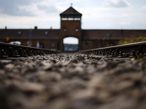FILE - In this June 25, 2015 file photo railway tracks lie in front of the main entrance of former Auschwitz-Birkenau Nazi death camp in Oswiecim, Poland. Poland's Senate has backed legislation regulating Holocaust speech, calling for up to three years in prison for any intentional attempt to falsely attribute the crimes of Nazi Germany to the Polish state or people.