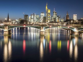 In this Feb. 13, 2018 photo the lights of the skyline of the Frankfurt, Germany, banking district are reflected in the river main after the sun set.