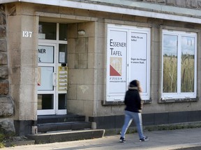 A woman passes by the food bank in the western German city Essen Friday, Feb. 23, 2018. The German food bank is being criticized after deciding to only register new users if they prove they've got German citizenship, claiming young foreign men are scaring away elderly people and women.