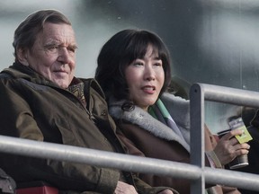 Former German Chancellor Gerhard Schroeder, left, and his South Korean fiancee Kim So-yeon watch the German Bundesliga soccer match between Hannover 96 and Borussia Moenchengladbach in Hannover, northern Germany, Saturday, Feb. 24, 2018.