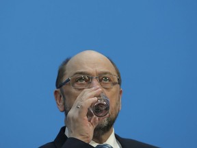 Martin Schulz, chairman of the Social Democratic Party, SPD, drinks water during a press statement after Merkel's conservatives and Germany's main center-left party reached a deal to form a new coalition government after a final session of talks that dragged on for 24 hours in the headquarters of the Christian Democratic Union in Berlin, Germany, Wednesday, Feb. 7, 2018.