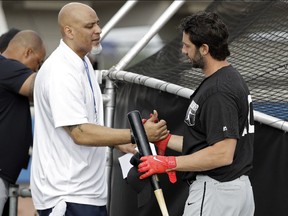 Tony Clark, left, head of the Major League Baseball Players Association, speaks with free agent Chris Colabello before an exhibition baseball game against JR East, a Japanese amateur team, on Tuesday, Feb. 27, 2018 in Bradenton, Fla.