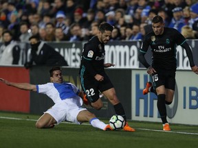 Real Madrid's Francisco Roman "Isco", centre, with Leganes' Gabriel Appelt, left, during a Spanish La Liga soccer match between Real Madrid and Leganes at the Butarque stadium in Leganes, outside Madrid, Wednesday, Feb. 21, 2018.