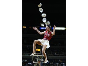 FILE - In this March 7, 2004 file photo, Rong Niu of China performs during the halftime break of the New York Knicks-Washington Wizards game by tossing the bowls with her right foot and catching them with her head as she balances on a unicycle in Washington. Someone at the San Francisco airport stole a 7-foot unicycle used by the Red Panda Acrobat for her plate-juggling routine and the legendary performer is offering a $2,000 reward to get it back. Police on Wednesday, Jan. 31, 2018, released surveillance photos from Jan. 24 that show a man wheeling away a black bag containing the $25,000 unicycle belonging to acrobat Rong Niu.