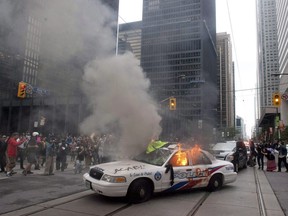 A police car burns after G20 summit protesters set fire to it in downtown Toronto on Saturday, June 26, 2010.