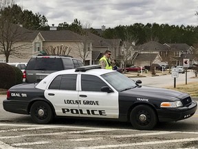 Authorities investigate the scene where multiple law enforcement officers have been shot and a suspect is dead south of Atlanta, Friday, Feb. 9, 2018, in Locust Grove, Ga. WSB-TV, citing the Henry County Sheriff's Office, reports that two local sheriff's deputies and a Locust Grove officer were shot. The sheriff says the man who shot them is dead.